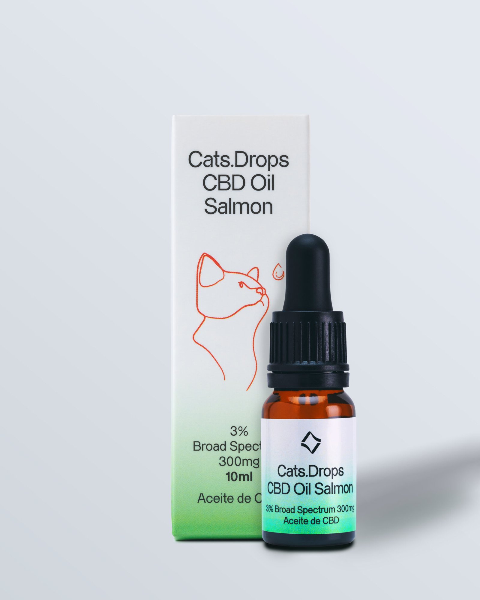 Frasco de vidrio de aceite de salmón para gatos con etiqueta 'Cats Drops CBD Oil salmón' frente a su caja.